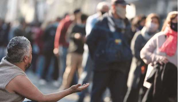 A man begs during the feast day of San Cayetano (Saint Cajetan), patron saint of labour and bread, at San Cayetano church in Buenos Aires, yesterday.