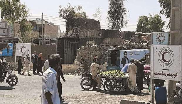 Afghan men walk along a road in Zaranj yesterday after Taliban captured their first provincial capital since launching an offensive to coincide with the departure of foreign troops.