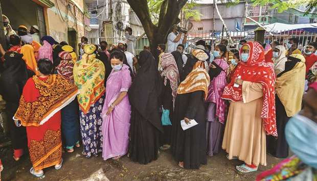People queue up to get inoculated with the Sinopharm Covid-19 vaccine during a mass vaccination camp at Kholamora in Keraniganj district, Bangladesh.