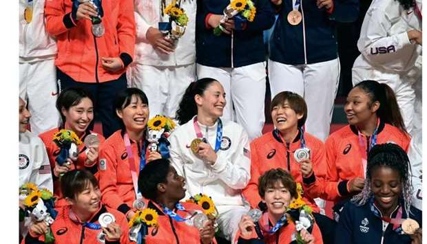First placed USA's Sue Bird (C) poses for pictures with her gold medal with second placed Japan's players (in red) and third placed players France's players (blue top) after the medal ceremony for the women's basketball competition of the Tokyo 2020 Olympic Games at the Saitama Super Arena in Saitama.