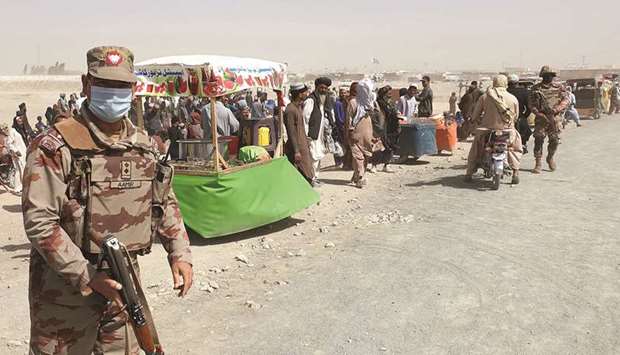 An army soldier patrols as stranded people wait for the reopening of the border crossing point which was closed by the authorities, in Chaman recently, after the Taliban took control of the border town.