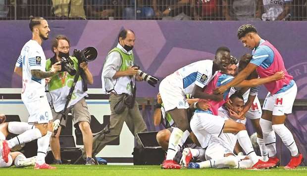 Marseilleu2019s players celebrate after scoring a goal against Montpellier during the French Ligue1 match at the Mosson stadium in Montpellier, southern France on Sunday night. (AFP)