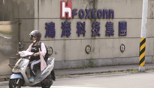 A motorist passes by a Foxconn office building in Taipei, Taiwan. Apple iPhone assembler Foxconn gave a cautious outlook for the current quarter after posting results that exceeded expectations, citing slowing smartphone demand after a pandemic-fuelled boom.