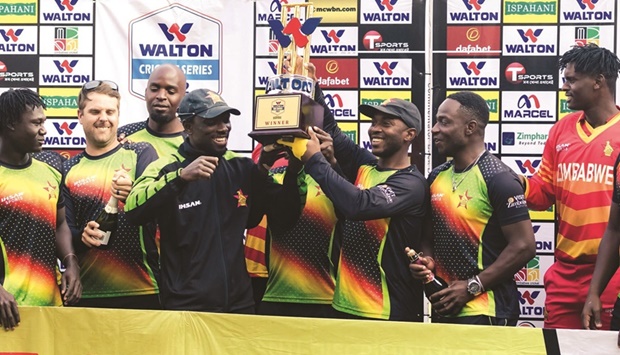 Zimbabwe players hold a trophy as they celebrate the series victory following the third ODI against Bangladesh at the Harare Sports Club yesterday. (AFP)