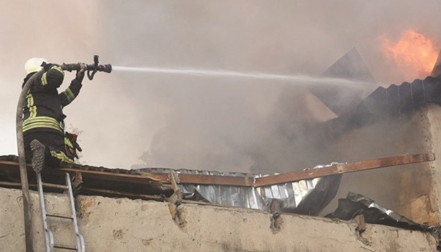 A firefighter works to douse a fire in a building in Mykolaiv yesterday. (Reuters)