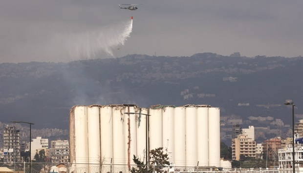 A Lebanese Army helicopter releases water over the heavily damaged grain silos at the port of the capital Beirut, yesterday, following a partial collapse.