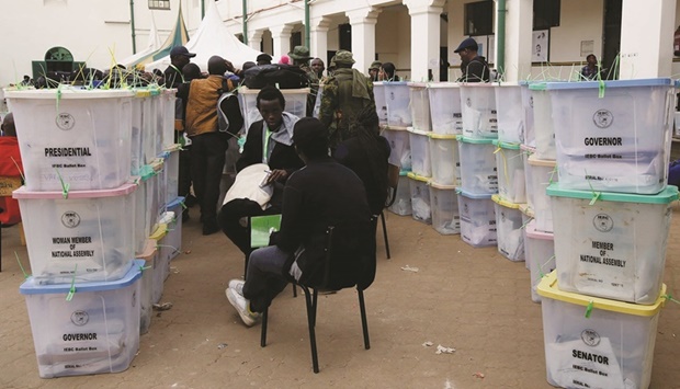 Police officers and polling staff sort sealed ballot boxes containing electoral materials at an Independent Electoral and Boundaries Commission (IEBC) tallying centre after the general election at the Jamuhuri High School in Nairobi.