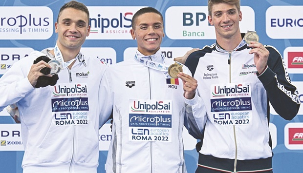 Gold medallist Romaniau2019s David Popovici (centre), silver medallist Hungaryu2019s Kristof Milak (left) and Bronze medallist Italyu2019s Alessandro Miressi pose on the podium after the menu2019s 100m freestyle final at the European Aquatics Championships in Rome yesterday. (AFP)
