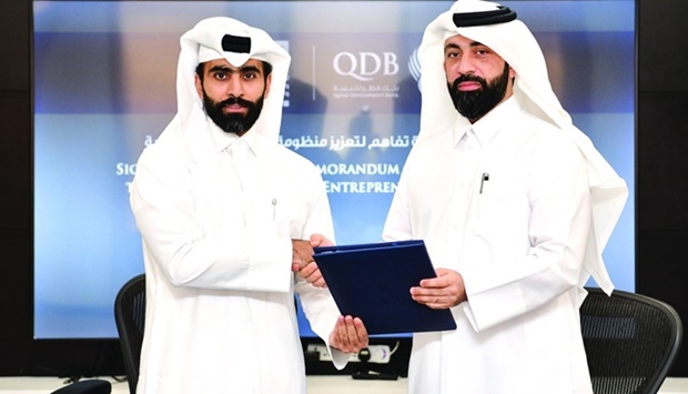 Abdulrahman Hesham al-Sowaidi, acting CEO of QDB, and engineer Omar Ali al-Ansari, secretary-general of QRDI Council, shaking hands after signing the MoU.