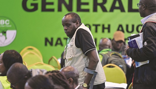 An election observer walks among Independent Electoral and Boundaries Commission clerks as they verify the just concluded presidential election results at the National Tallying Centre at the Bomas of Kenya in Nairobi yesterday. (AFP)