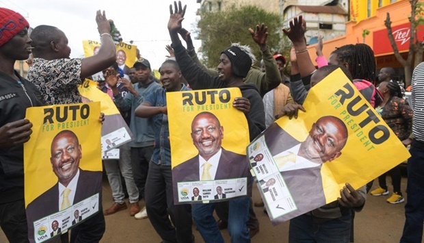 Kenya's Deputy President and presidential candidate of Kenya Kwanza (Kenya First) political party coalition William Ruto supporters hold posters of him as they gather while waiting for results of Kenya's general election in Eldoret. AFP