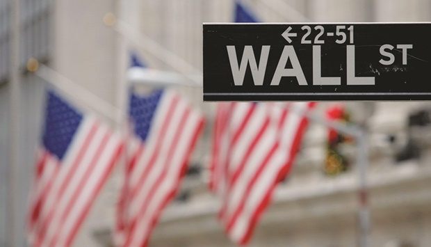 A street sign for Wall Street is seen outside the New York Stock Exchange in New York City. The PIFu2019s most recent buying spree echoes the fundu2019s strategy in early 2020 when it spent billions snapping up stakes in US firms whose valuations had been battered by the onset of the coronavirus pandemic. It then sold many of those stakes when markets rebounded.