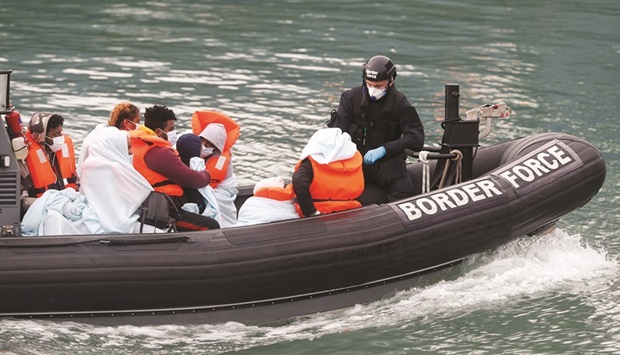 Border Patrol agents bring migrants into Dover harbour on a boat after they tried to cross the channel in Dover, Britain, in this 2020 file photo. (Reuters)