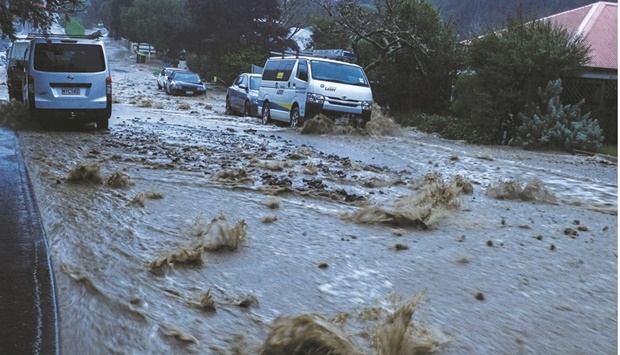 Motorists make their way through a flooded street in Nelson, South Island, New Zealand.