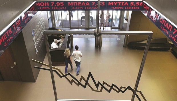 People walk through the lobby of the Athens Stock Exchange (file). Greece yesterday concluded 12 years of European Union fiscal surveillance that was imposed in return for bailouts after a crushing debt crisis.