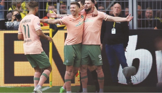 Werder Bremenu2019s Oliver Burke (right) celebrates with teammates after scoring a goal against Borussia Dortmund in the Bundesliga at Signal Iduna Park in Dortmund, Germany, yesterday. (Reuters)