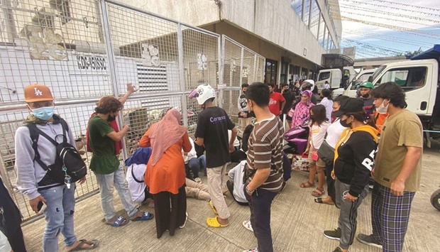 People receiving medical attention after getting hurt in a crush for educational cash aid ahead of the reopening of schools, in Zamboanga City.