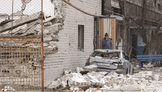 FILE PHOTO: A local resident stands near an apartment building damaged during Ukraine-Russia conflict in the southern port city of Mariupol, Ukraine, on April 4, 2022.