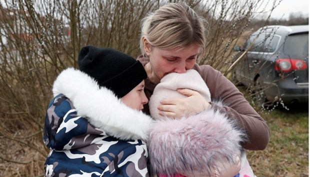 Anna Semyuk, 33, hugs her children at the Beregsurany border crossing, Hungary, February 26, 2022. The children were handed at the Ukrainian side of the border by the father, who is not allowed to cross, to Nataliya Ableyeva, 58, a stranger to the family who took the children across the border and kept them safe. REUTERS