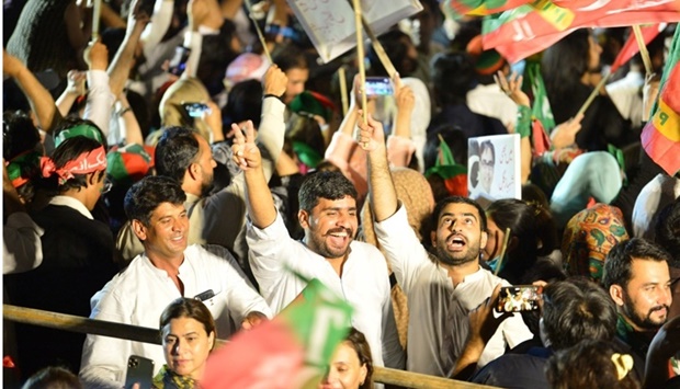 Supporters of Pakistan's former Prime Minister and leader of the Pakistan Tehreek-e-Insaf party (PTI) Imran Khan, wave flags during an anti-government protest rally in Islamabad on August 20