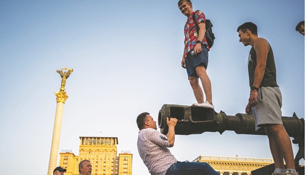 People climb on a destroyed Russian vehicle at Kyivu2019s u2018Maidanu2019 Independence Square, which has been turned into an open-air military museum ahead of Ukraineu2019s Independence Day tomorrow.