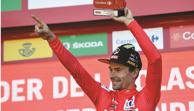 Team Jumbou2019s Slovenian rider Primoz Roglic celebrates on the podium holding the trophy and wearing the overall leaderu2019s red jersey after winning the 4th stage of the 2022 La Vuelta in Laguardia, Spain, yesterday. (AFP)