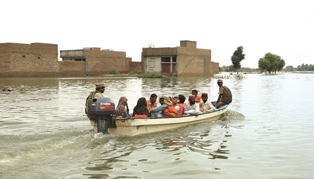 Army soldiers use a boat to evacuate stranded residents following heavy monsoon rainfall in the flood affected area of Rajanpur district in Punjab province yesterday.