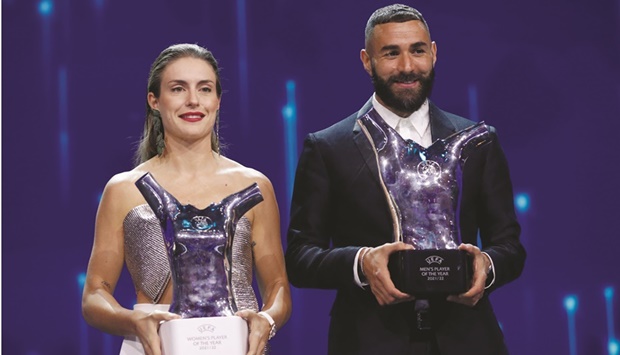 Barcelonau2019s Spanish forward Alexia Putellas (left) and Real Madridu2019s French forward Karim Benzema pose with their player of the year trophies in Istanbul yesterday. (AFP)