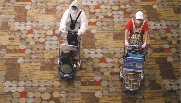 Passengers wearing protective gear at Singaporeu2019s Changi Airport following the outbreak of Covid-19 in a file picture.