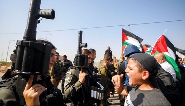 A Palestinian boy shouts at an Israeli border police officer during a protest against Israeli settlement activity, in Qalqilya in the Israeli-occupied West Bank yesterday.