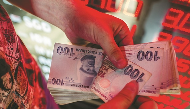 A money changer counts Turkish lira banknotes at a currency exchange office in Istanbul (file). Banksu2019 profits soared this year as they continued to lend with rates much higher than the central banku2019s one-week repo rate, which it uses to fund the market.