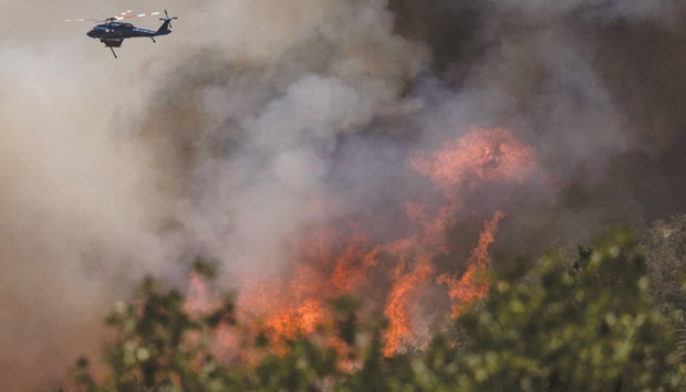 A firefighting helicopter drops water on a hillside to control the Oak Fire as it burns near Darrah in Mariposa County, California, last month. (Reuters)