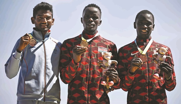 Gold-medallist Kenyau2019s Abraham Kibiwot (centre) poses on the podium with silver-medallist Indiau2019s Avinash Mukund Sable (left) and bronze-medallist Kenyau2019s Amos Serem during the podium ceremony for the menu2019s 3000m steeplechase yesterday. (AFP)