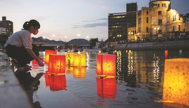 People release paper lanterns on the Motoyasu River beside the Hiroshima Prefectural Industrial Promotion Hall, commonly known as the atomic bomb dome, to mark the 77th anniversary of the worldu2019s first atomic bomb attack in Hiroshima yesterday.