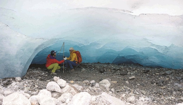 Glaciologists Andrea Fischer (right) and Violeta Lauria from the Austrian Academy of Sciences measure the height under a part of the ice shelf of the Jamtal Glacier near Galtuer, Tyrol, Austria. (AFP)