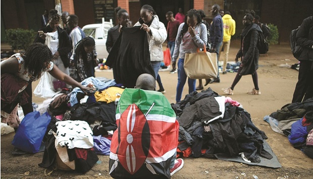 A man, wearing a Kenyan national flag, sells secondhand clothes in Eldoret town yesterday, ahead of Kenyau2019s general election.