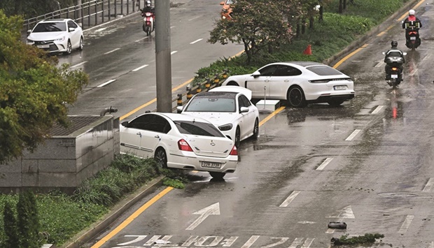 Cars damaged by floodwaters are seen on a street in Gangnam district, Seoul, yesterday.