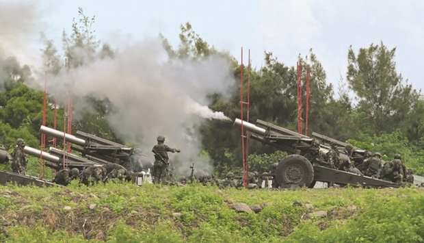 Taiwan military soldiers fire the 155-inch howitzers during a live fire anti landing drill in the Pingtung county, southern Taiwan, yesterday.