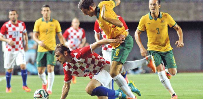    Croatiau2019s Nikita Jelavic falls while battling Australiau2019s Matthew Spiranovic during their friendly match in Salvador on Friday. (Reuters)