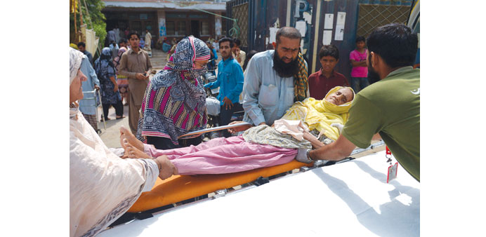 HEATWAVE IN KARACHI: Relatives shift a heatstroke victim to a hospital in Karachi, Pakistan on July 1.     Photo by AFP