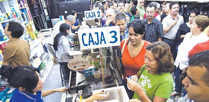Shoppers queue to buy electronic items in a store in Caracas.