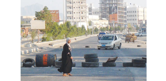 A girl walks past roadblocks at the northern entrance to Aden.