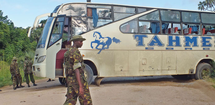 Police officers stand at the scene where a bus and a police vehicle were attacked by gunmen on Friday near the town of Witu, on Kenyau2019s restive southe