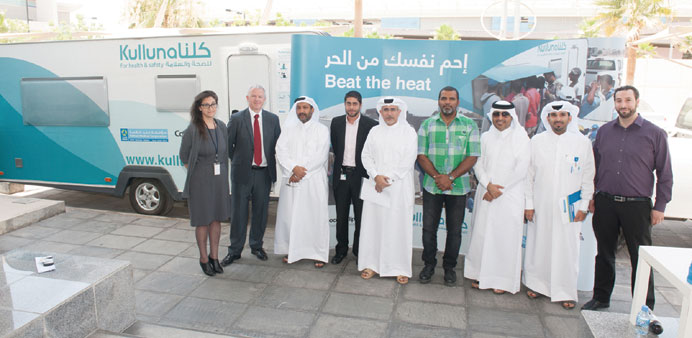 Dr Saifeldeen, Sykes and others pose next to the Kulluna Beat the Heat campaign caravan.