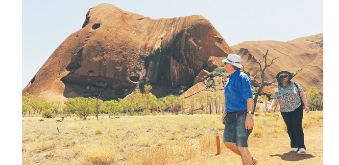 (File photo) Tourists walk along the base of Uluru in the Northern Territory, Australia.