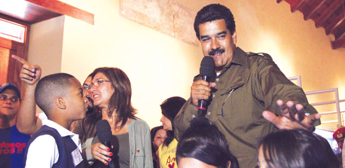 Venezuelau2019s acting President and presidential candidate Nicolas Maduro talks to children during an opening ceremony of a museum in Caracas.