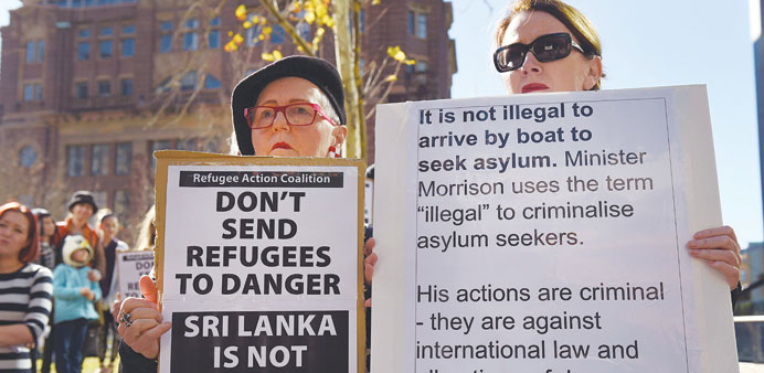 Two people hold placards at a rally protesting the Australian governmentu2019s treatment of Sri Lankan asylum-seekers in Sydney.