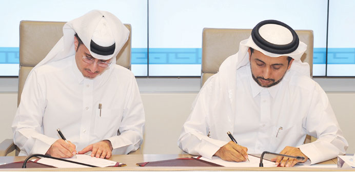 Dr Hassan al-Derham and Yousef al-Naama signing the agreement.