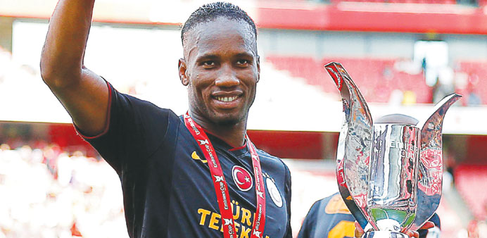 Didier Drogba of Galatasaray celebrates with the trophy after the Emirates Cup pre-season match against Arsenal in London yesterday. (EPA)