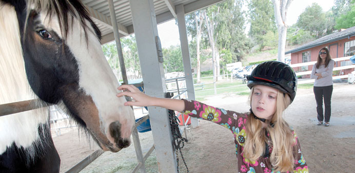 HEALING TOUCH: Darcelle Scott rode with Lady Chandora during a therapeutic riding session with Senecau2019s Guided Animal Intervention Therapy in Orange, 